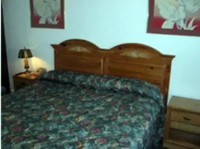 a bedroom with a bed with a wooden head board at Red Carpet Inn & Suites Morgantown in Morgantown