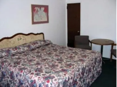 a bedroom with a bed and a table at Red Carpet Inn & Suites Morgantown in Morgantown