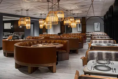 a dining room with tables and chairs and chandeliers at The Alloy, a DoubleTree by Hilton - Valley Forge in King of Prussia