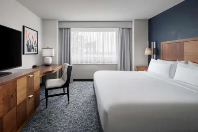 a hotel room with a bed and a desk and a television at The Alloy, a DoubleTree by Hilton - Valley Forge in King of Prussia