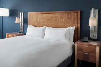 a large white bed in a hotel room with two lamps at The Alloy, a DoubleTree by Hilton - Valley Forge in King of Prussia