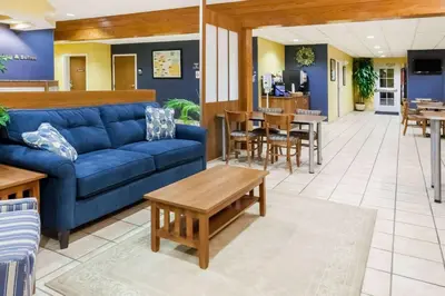 a living room with a blue couch and tables at Microtel Inn & Suites in Dickson City