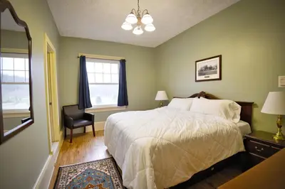 a bedroom with a bed and a chair and a window at Shawnee Inn and Golf Resort in East Stroudsburg