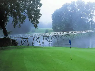 a bridge over a body of water with a golf green at Shawnee Inn and Golf Resort in East Stroudsburg