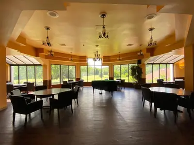 a dining room with tables and chairs and windows at Shawnee Inn and Golf Resort in East Stroudsburg