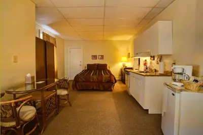 a kitchen with a table and a bed in a room at Suites on Main in Margaretville