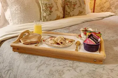 a tray of food on a bed with a plate of food at Margaretville Mountain Inn B&B in Margaretville