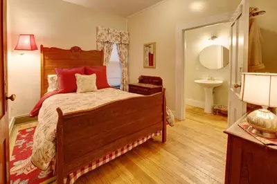 a bedroom with a wooden bed with red pillows at Margaretville Mountain Inn B&B in Margaretville