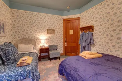 a bedroom with a bed and a chair and a table at Margaretville Mountain Inn B&B in Margaretville