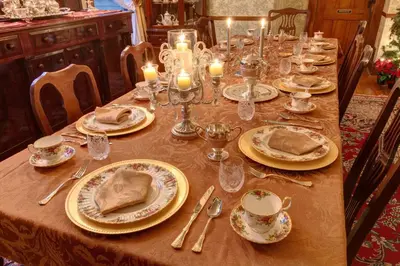 a table with plates and glasses and candles on it at Margaretville Mountain Inn B&B in Margaretville