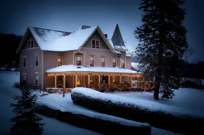 a large house covered in snow at night at Margaretville Mountain Inn B&B in Margaretville