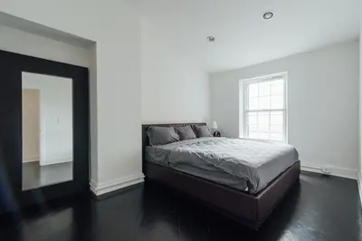 a bedroom with a large bed and a mirror at The Havana Lofts in Philadelphia