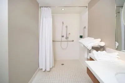 a white bathroom with a shower and a sink at SpringHill Suites by Marriott Philadelphia Valley Forge/King of Prussia in King of Prussia