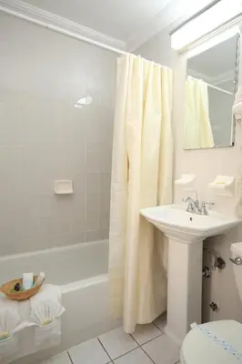 a bathroom with a sink and a tub and a toilet at Radio City Apartments in New York