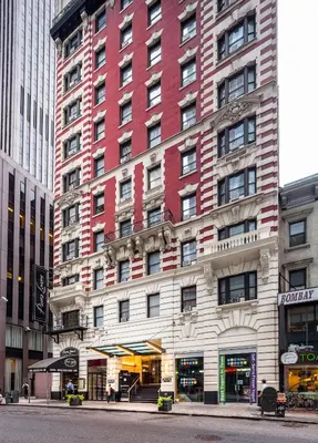 a tall red and white building on a city street at Radio City Apartments in New York
