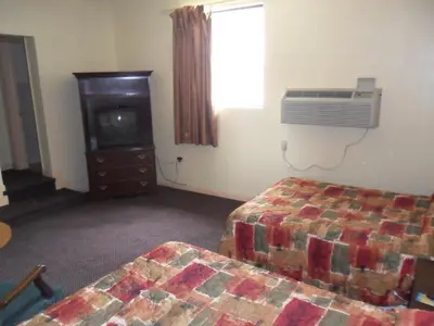 a bedroom with a bed and a tv and a window at Red Carpet Inn Brooklawn in Brooklawn