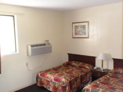 a hotel room with two beds and a air conditioner at Red Carpet Inn Brooklawn in Brooklawn