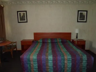 a hotel room with a bed with a colorful blanket at Red Carpet Inn Brooklawn in Brooklawn