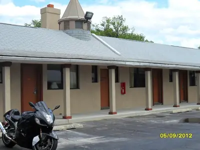 a motorcycle parked in a parking lot in front of a building at Red Carpet Inn Brooklawn in Brooklawn