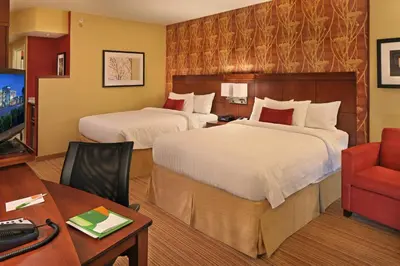 a hotel room with two beds and a desk at Courtyard Philadelphia Coatesville Exton in Coatesville