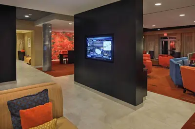 a hotel lobby with a tv on a wall at Courtyard Philadelphia Coatesville Exton in Coatesville