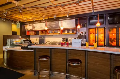 a bar in a restaurant with stools at Courtyard Philadelphia Coatesville Exton in Coatesville