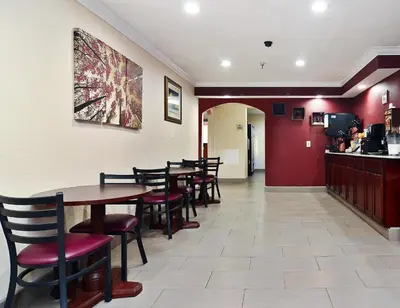 a dining room with tables and chairs in a restaurant at Red Roof Inn Binghamton North in Binghamton