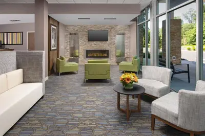 a lobby with couches and chairs and a fireplace at Holiday Inn Express & Suites - North Brunswick by IHG in North Brunswick