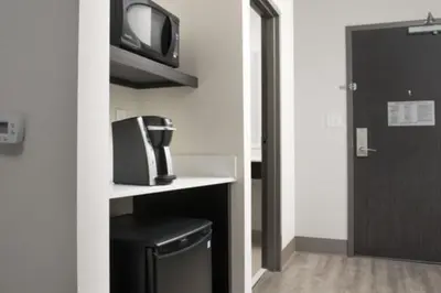 a small room with a microwave and a tv on a shelf at Holiday Inn Express & Suites - North Brunswick by IHG in North Brunswick
