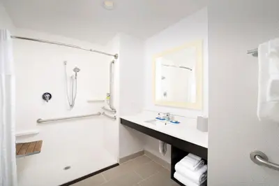 a white bathroom with a sink and a shower at Holiday Inn Express & Suites - North Brunswick by IHG in North Brunswick