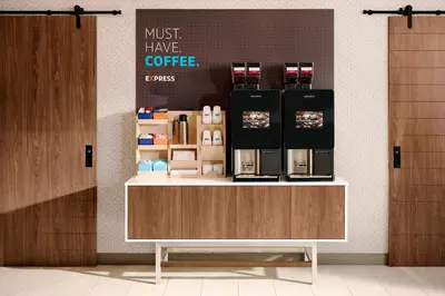 a coffee shop with a counter with a coffee maker on it at Holiday Inn Express & Suites - North Brunswick by IHG in North Brunswick