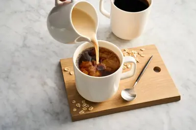 a cup of coffee on a wooden board with a tea pot at SpringHill Suites by Marriott Scranton Montage Mountain in Moosic
