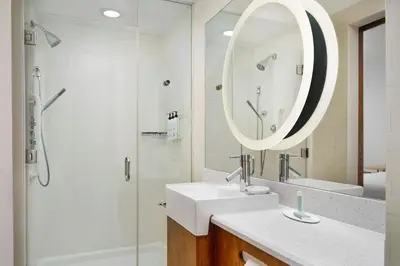 a bathroom with a sink and a shower and a mirror at SpringHill Suites by Marriott Scranton Montage Mountain in Moosic