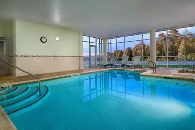 a large swimming pool with blue water and windows at SpringHill Suites by Marriott Scranton Montage Mountain in Moosic