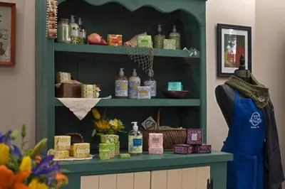 a store with a green shelf with bottles on it at 1825 Inn Bed and Breakfast in Palmyra