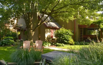 a yard with two chairs and a tree and a house at The Lancaster Bed and Breakfast in Lancaster