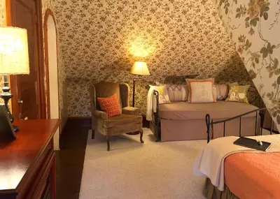 a bedroom with a bed and a chair and a lamp at The Lancaster Bed and Breakfast in Lancaster