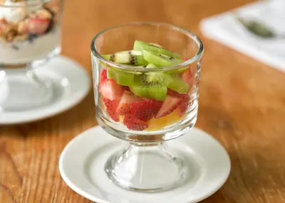 a glass vase filled with fruit on a plate at The Lancaster Bed and Breakfast in Lancaster