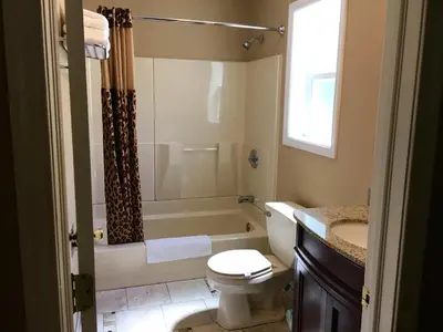 a bathroom with a toilet and a tub and a sink at Scottish Inns Milford in Milford