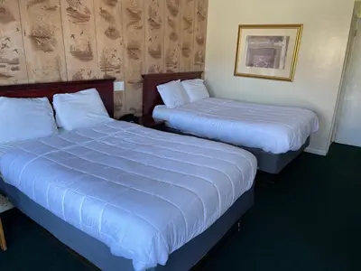 two beds in a hotel room with blue sheets at Paramount Motel Pocono in East Stroudsburg