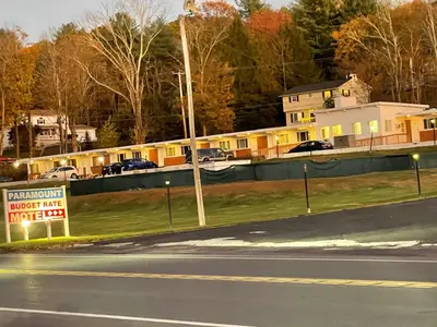 a sign on the side of a road next to a house at Paramount Motel Pocono in East Stroudsburg