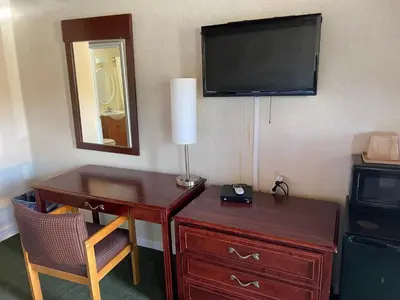 a room with a desk with a television and a dresser at Paramount Motel Pocono in East Stroudsburg