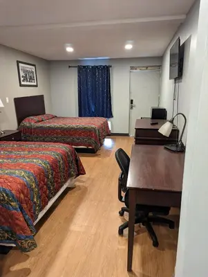 a hotel room with two beds and a desk and a desk at Executive Inn Coopersburg in Coopersburg