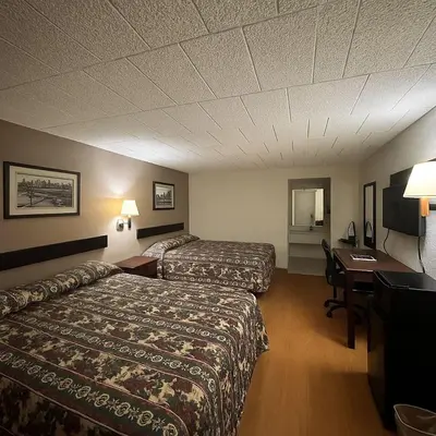 a hotel room with two beds and a desk at Executive Inn Coopersburg in Coopersburg