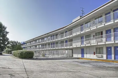 a large white building with blue doors and windows at Motel 6-New Cumberland, PA - Harrisburg - Hershey South in New Cumberland