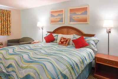 a bedroom with a large bed with colorful pillows at Rodeway Inn Milford - I-84 in Milford