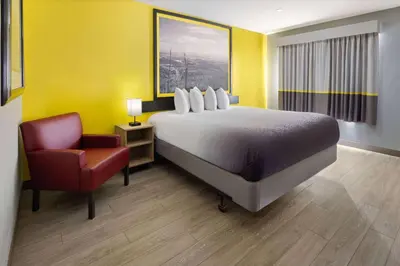 a hotel room with a bed and a chair at Super 8 by Wyndham Hazleton in Hazleton