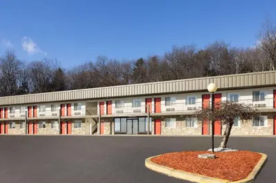 a building with red windows and a tree in front of it at Super 8 by Wyndham Hazleton in Hazleton