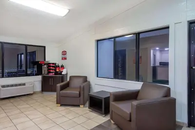 a waiting room with two chairs and a window at Travelodge by Wyndham Essington / Philadelphia Airport in Essington