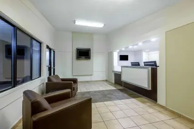 a waiting room with two chairs and a tv at Travelodge by Wyndham Essington / Philadelphia Airport in Essington